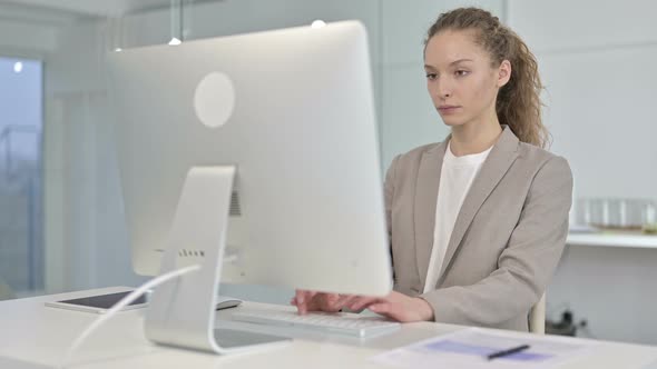 Ambitious Young Businesswoman Working on Desk Top in Office