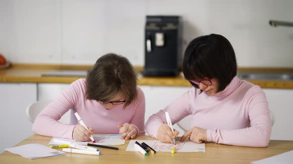 Two Girls Draw with Colorful Pens at Home