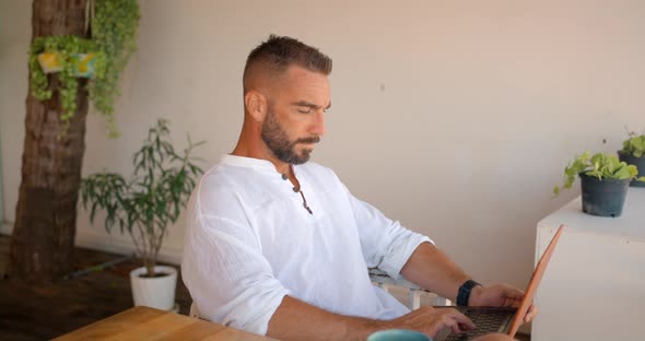 Businessman Working While Rest in the Open Summer Cafe Drinking Coffee and Chatting with His Staff