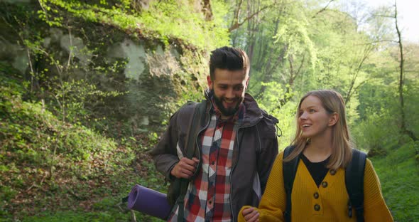 A Guy and a Girl Are Talking and Walking Through the Forest