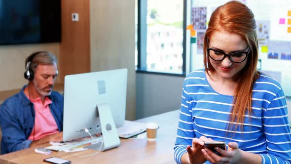 Female executive using mobile phone