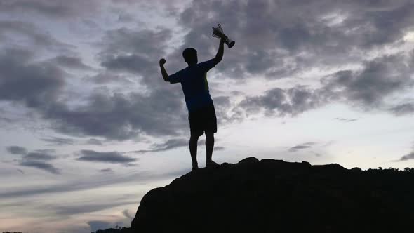 Silhouette Man Rejoicing With Champion Cup On The Top