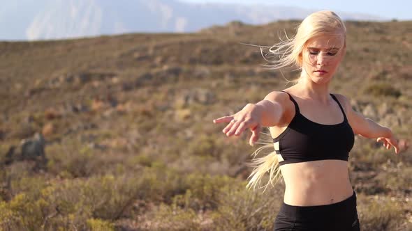 Beautiful blond female model doing yoga in nature with stunning scenery