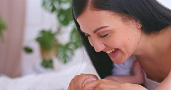 Portrait Happy Mom Smiles at the Baby and Talks to Him