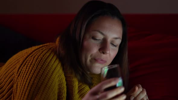 Cheerful Woman Drinking Wine and Chatting Online