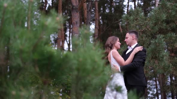 Happy Smiling Newlyweds Couple Holding Each Other on Their Wedding Day in Nature