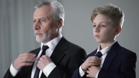 Adult Man and Little Boy in Business Suits Adjusting Ties, Future Successor