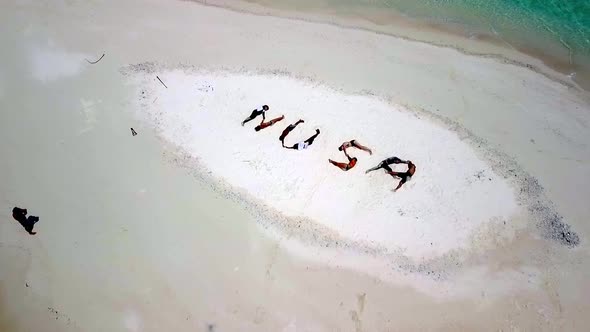 People form NUSA letters meaning island in the Indonesian language on a tiny sandy isle in Raja Ampa