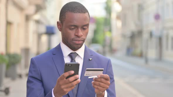 Outdoor African Businessman Having Online Payment Success on Smartphone