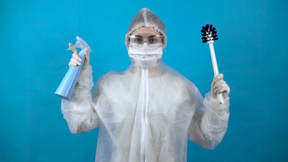 A Young Woman in a Protective Suit with a Toilet Brush and a Dispenser in Her Hands. Protection