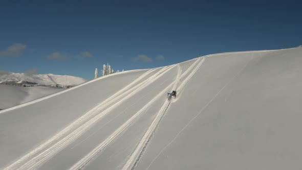 Aerial View Man Extreme Riding Downhill on Snowmobile By Snowy Slope Mountain