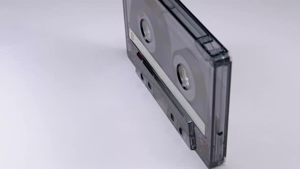 Vintage Transparent Audio Cassette Rotates on White Background