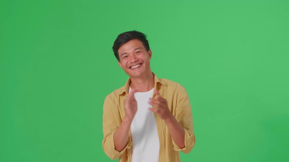 Young Asian Man Clapping Her Hands In The Green Screen Studio