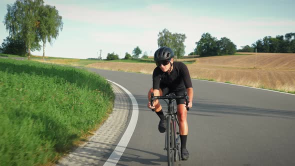 Woman cycling on road bike downhill