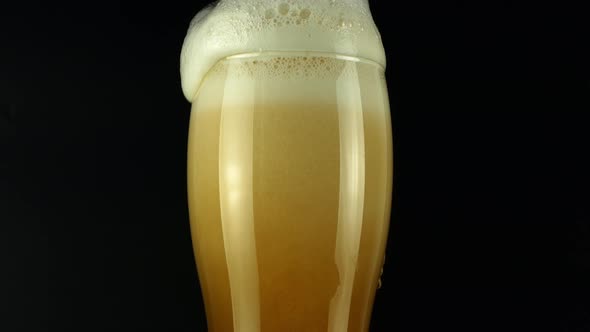 Rotate the light beer into the glass. Cold light beer in a glass with water drops.