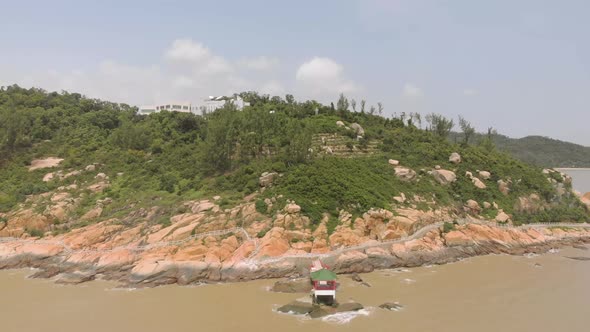 Zoom out aerial shot revealing Coloane coastline and traditional Chinese pavilion