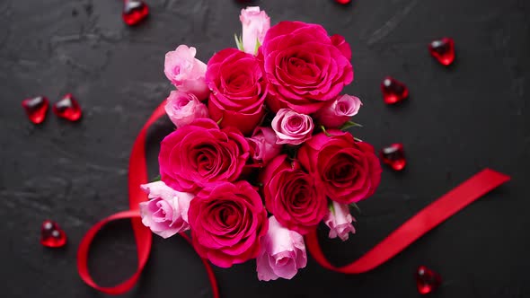 Pink Roses Bouquet Packed in Red Box and Placed on Black Stone Background