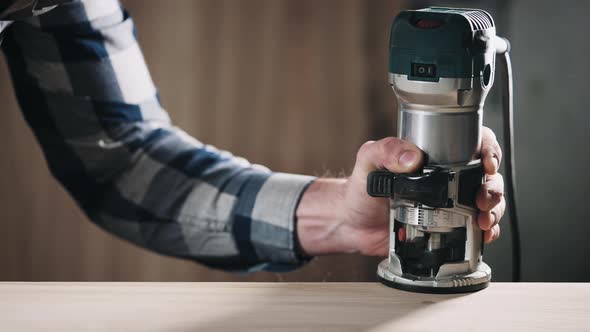 The Carpenter Makes a Chamfer on the Countertop Using a Specialized Power Tool