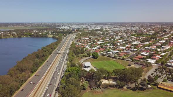 Aerial, busy freeway between residential suburb and lake, Perth, Australia