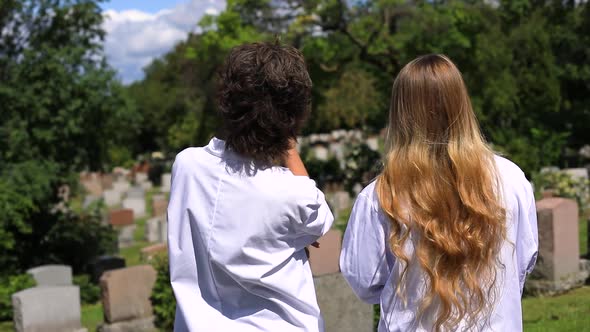 Two Woman in Cemetery Talking Seeing Around