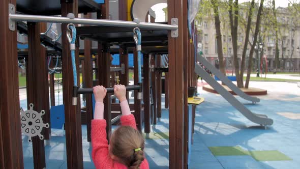 Junior Schoolgirl with Long Plait Hangs on Metal Swing