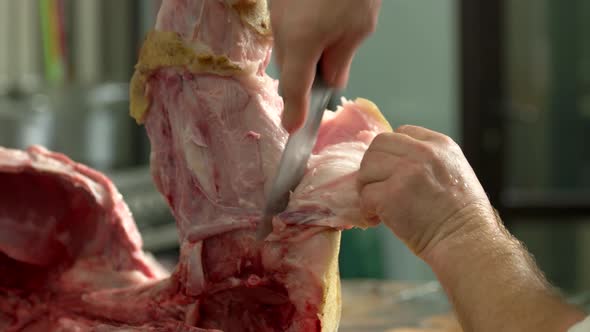 Close Up Butcher Removing the Skin From Pig Leg