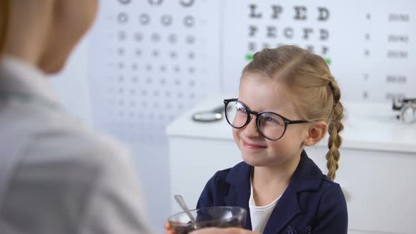 Ophthalmologist Giving Blueberries to Cute Little Girl, Natural Vitamin for Eyes