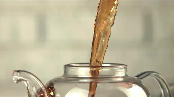 A Super Slow Motion Jet of Black Tea Pours Into the Teapot