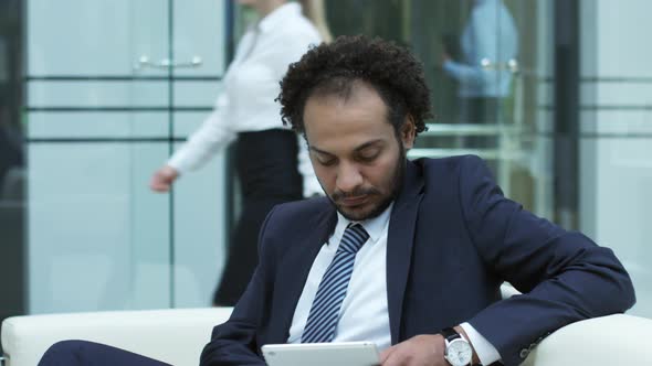 Middle Eastern Businessman Using Tablet in Office Center