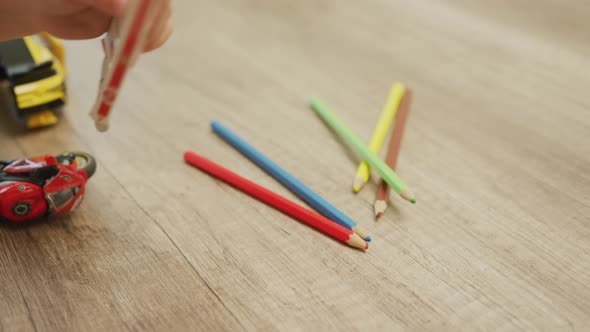 Child's hand playing with pencils