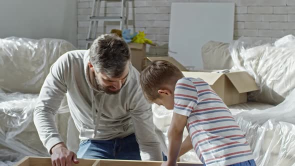 Father Teaching Child to Use Electric Screwdriver