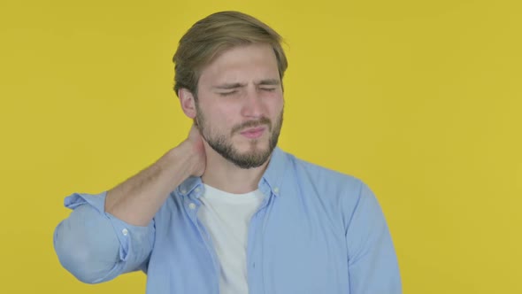 Young Man with Neck Pain on Yellow Background