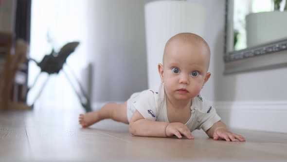 Crawling Infant Baby Lying on Floor Indoors Learning Crawl to Camera Emotions