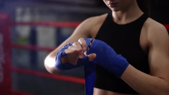 Woman Fighter Wraps Her Hands with Boxing Bandages