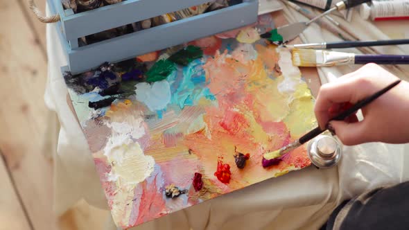 Professional Paintress Mixing Oil Paints on Palette Using Brush, Hand Closeup.