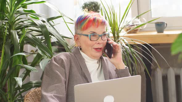 Happy Businesswoman Sitting in Business Center with Laptop and Smartphone