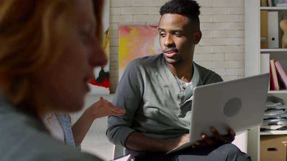 Relaxed Afro-American IT Specialist at Meeting