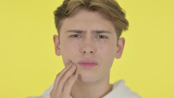 Close Up of Young Man with Toothache Yellow Background