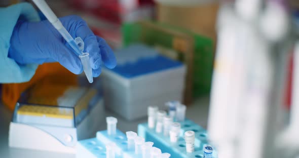 Female Scientist Injecting Liquid or Virus Into Flask in Laboratory