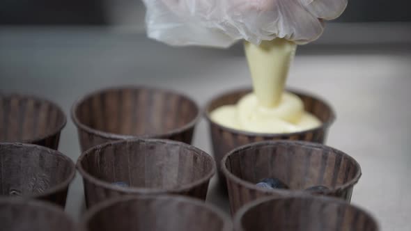 Hand Pouring Cake Dough Into Muffin Tray