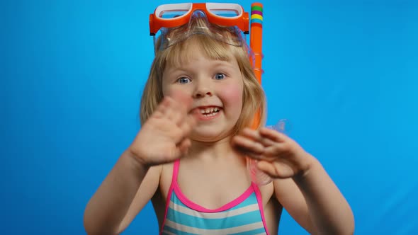 Little Blond Girl with Short Hair in Swimsuit is Waving Her Hands in the Studio