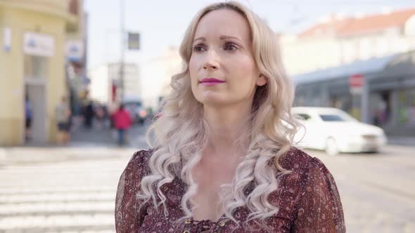 A Middleaged Caucasian Woman Looks Around in Puzzlement in an Urban Area