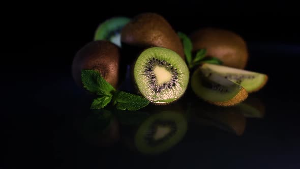 Fruits of Juicy Kiwi Rotate on a Table on a Black Background