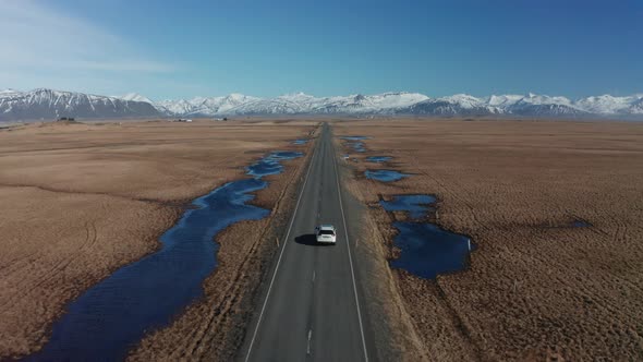 Aerial View of a Moving Car on a Deserted Road in Iceland in Early Spring