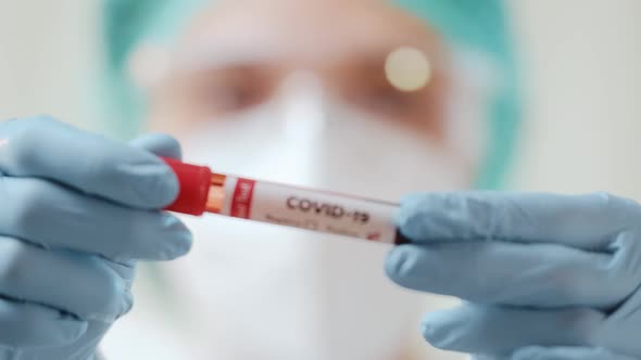 Female Doctor Holds a Blood Test Tube To Check a Blood Sample for the COVID-19 Virus.