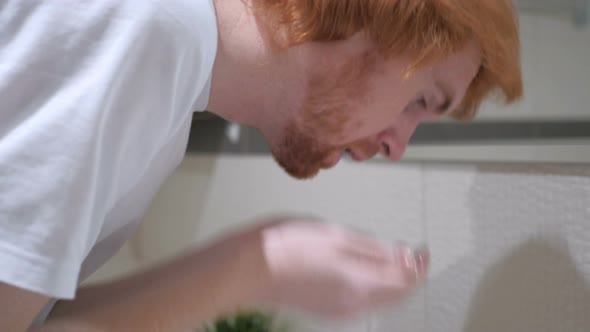 Redhead Man Washing Face in Sink, Washroom