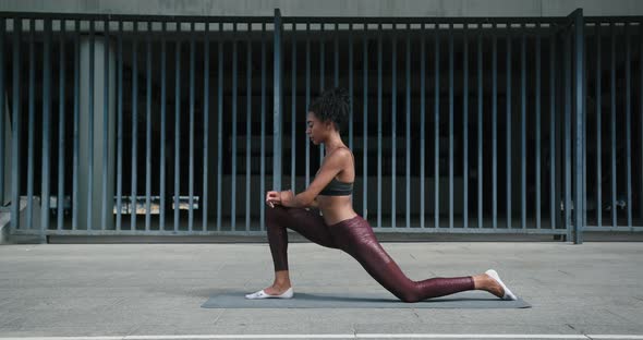 AfricanAmerican Woman Does Yoga Exercises on Street