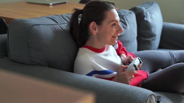 Woman at Home Playing Video Games with Wireless Gamepad