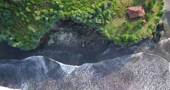 Overhead sliding drone shot of coastline with green trees. Cliff border with sea. The south coast of