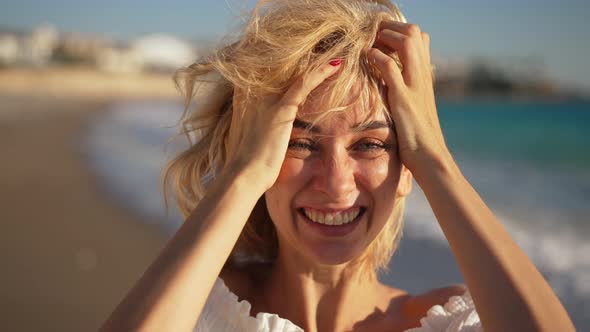 Headshot Portrait of Joyful Caucasian Young Beautiful Woman with Toothy Smile Tossing Hair in Slow